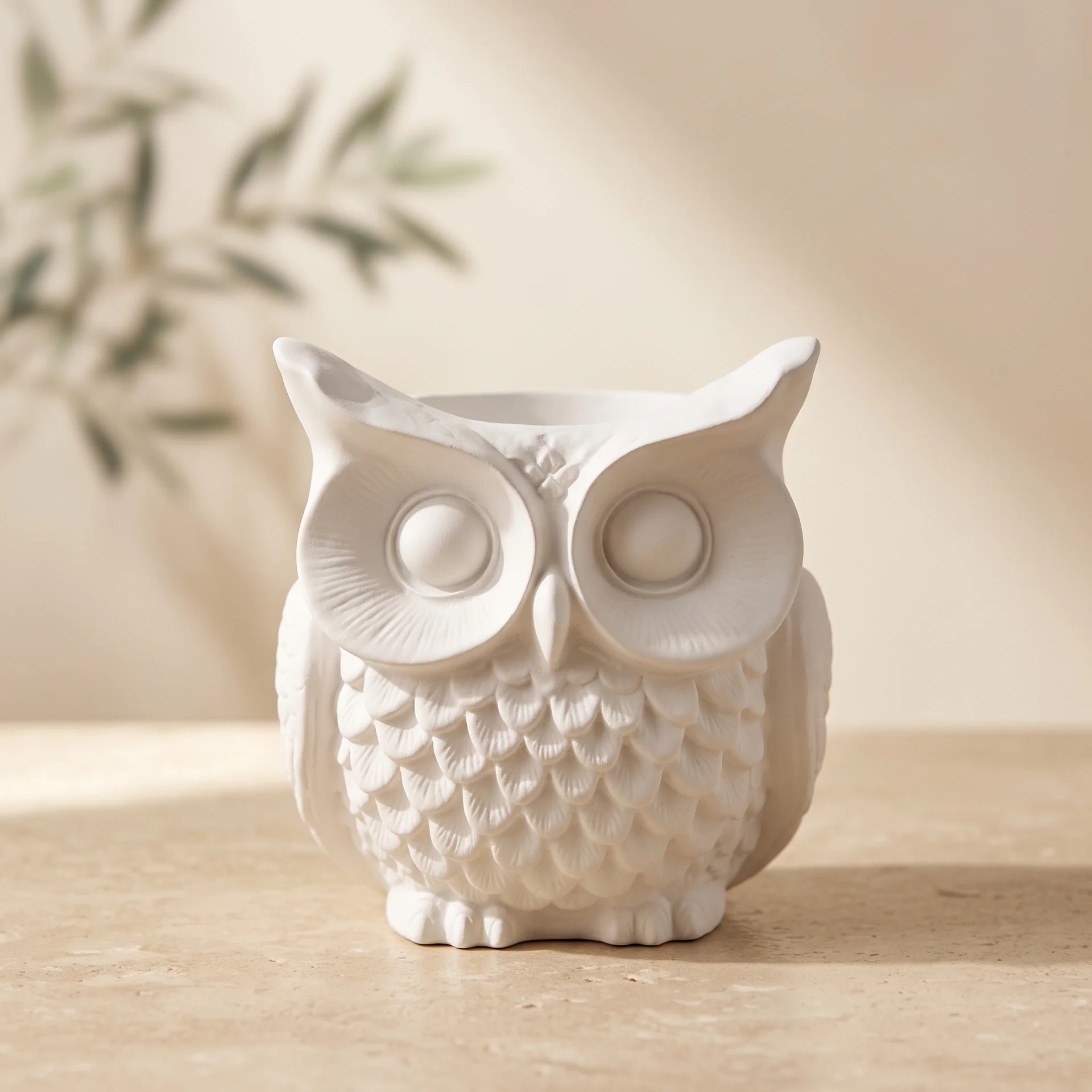 Portalápices decorativo con forma de búho en yeso cerámico blanco mate sobre escritorio minimalista